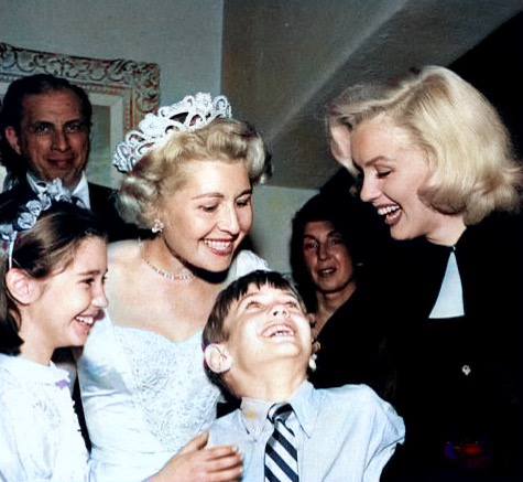 I’m the 7 year old kid gazing up at Marilyn Monroe with goofy admiration just as she was about to swoop down and kiss me. It’s a kiss that’s followed me throughout my life, a blessing that’s lingered. The year was 1952. My mother is hovering above me and my sister, Wendy, is on my right.